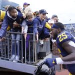 
              Michigan running back Hassan Haskins greets fans after the second half of an NCAA college football game against Northwestern, Saturday, Oct. 23, 2021, in Ann Arbor, Mich. (AP Photo/Carlos Osorio)
            