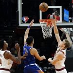 
              Cleveland Cavaliers forward Lauri Markkanen, right, jumps to block a shot by Phoenix Suns guard Devin Booker, middle, as Cavaliers center Evan Mobley (4) watches during the first half of an NBA basketball game Saturday, Oct. 30, 2021, in Phoenix. (AP Photo/Ross D. Franklin)
            