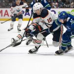 
              Vancouver Canucks' Quinn Hughes, right, tries to check Edmonton Oilers' Derek Ryan off the puck during the first period of an NHL hockey game Saturday, Oct. 30, 2021, in Vancouver, British Columbia. (Rich Lam/The Canadian Press via AP)
            