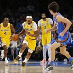 
              Los Angeles Lakers forward Kent Bazemore (9) drives the ball against Oklahoma City Thunder guard Josh Giddey (3) while Los Angeles Lakers guard Rajon Rondo (4) and forward Anthony Davis (3) look on during the first half of an NBA basketball game, Wednesday, Oct. 27, 2021, in Oklahoma City. (AP Photo/Garett Fisbeck)
            