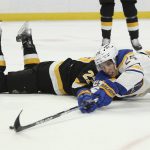 
              Buffalo Sabres center Dylan Cozens (24) attempts to shoot while falling to ice after colliding with Boston Bruins defenseman John Moore during the first period of an NHL hockey game Friday, Oct. 22, 2021, in Buffalo, N.Y. (AP Photo/Joshua Bessex)
            