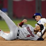 
              Kansas City Royals' Nicky Lopez, back, is caught stealing second by Minnesota Twins shortstop Andrelton Simmons (9) during the fourth inning of a baseball game Saturday, Oct. 2, 2021, in Kansas City, Mo. (AP Photo/Charlie Riedel)
            