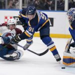 
              Colorado Avalanche's Jacob MacDonald, left, tries to get off a shot as St. Louis Blues goaltender Jordan Binnington (50) and Vladimir Tarasenko (91) defend during the third period of an NHL hockey game Thursday, Oct. 28, 2021, in St. Louis. (AP Photo/Jeff Roberson)
            