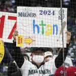 
              A Seattle Mariners fan holds a sign encouraging the Mariners to sign Los Angeles Angels' Shohei Ohtani in 2024 before a baseball game between the two teams, Sunday, Oct. 3, 2021, in Seattle. (AP Photo/Ted S. Warren)
            