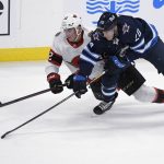 
              Winnipeg Jets' Riley Nash (20) and Ottawa Senators' Shane Pinto (12) battle for the puck during the second period of an NHL preseason hockey game in Winnipeg, Manitoba, Sunday, Sept. 26, 2021. (Fred Greenslade/The Canadian Press via AP)
            