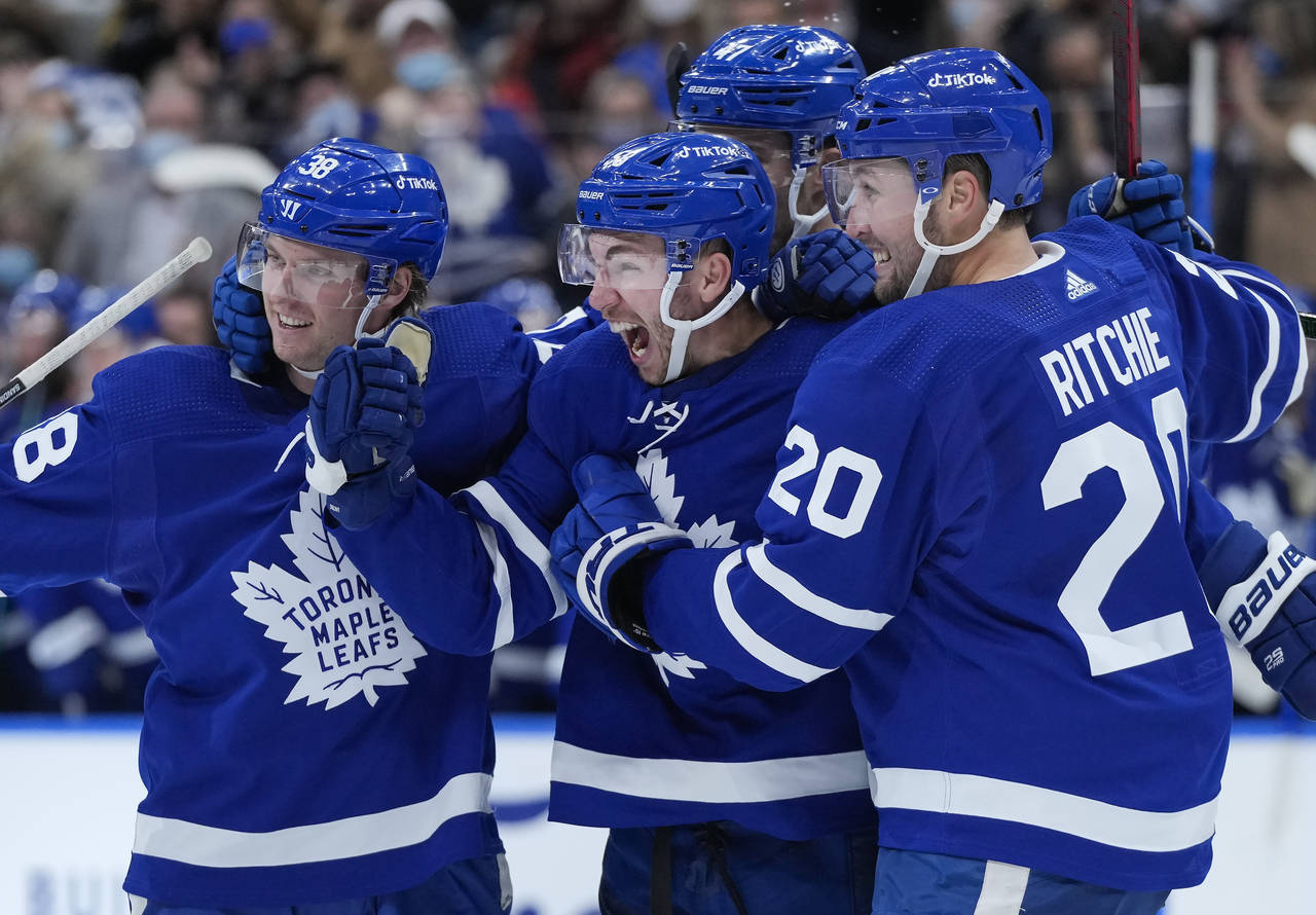 Toronto Maple Leafs forward Michael Bunting, center, celebrates his goal with teammates while playi...