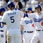 
              Los Angeles Dodgers' Trea Turner, right, gets congratulations from Corey Seager (5), Mookie Betts (50), and Matt Beaty (45), after Turner hit a grand slam home run against the Milwaukee Brewers during the fifth inning of a baseball game in Los Angeles, Sunday, Oct. 3, 2021. (AP Photo/Alex Gallardo)
            