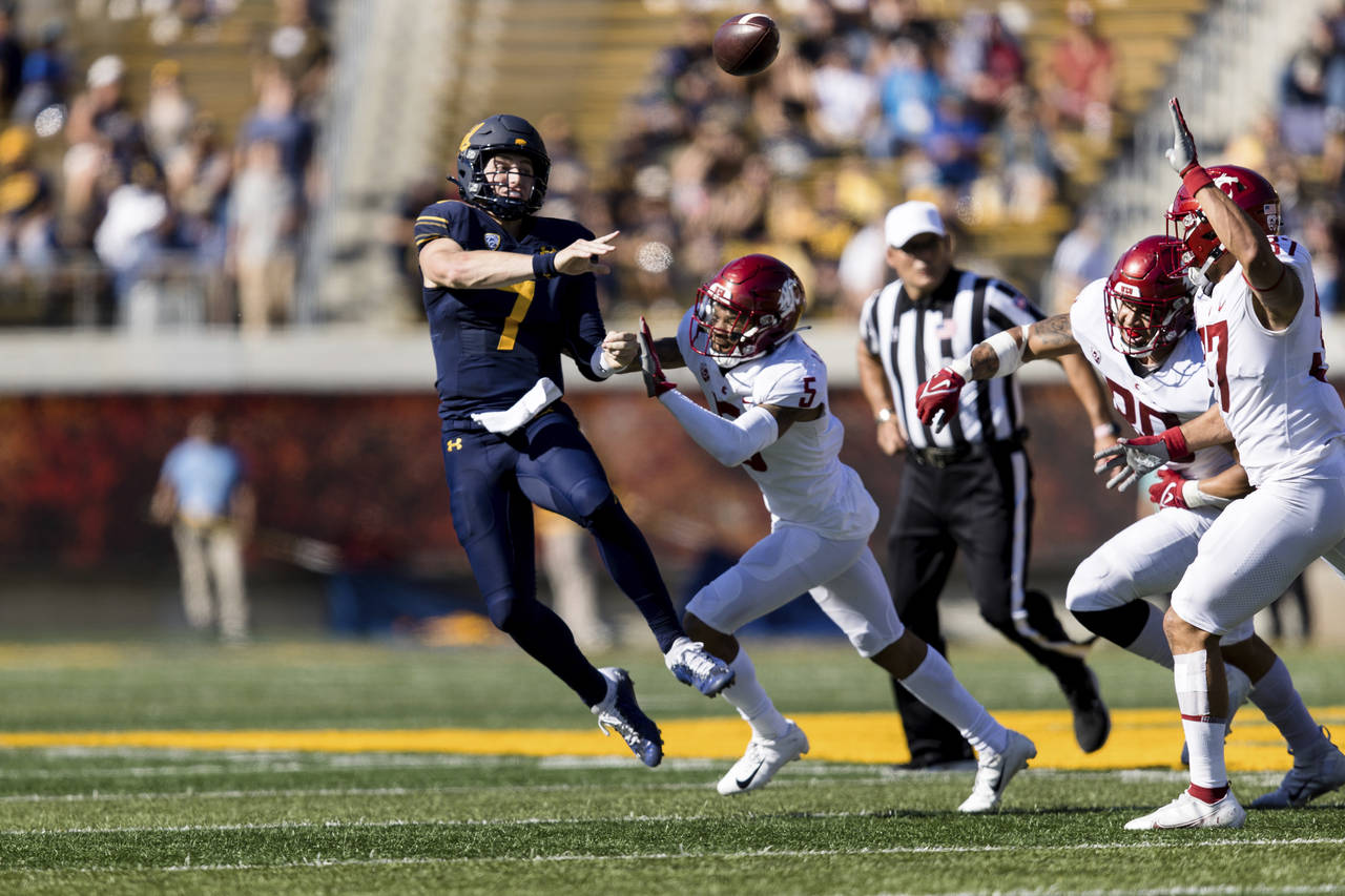 California quarterback Chase Garbers (7) throws a pass under pressure from Washington State defensi...
