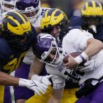 
              Northwestern quarterback Ryan Hilinski is sacked by Michigan defensive ends Mike Morris (90) and Aidan Hutchinson during the first half of an NCAA college football game, Saturday, Oct. 23, 2021, in Ann Arbor, Mich. (AP Photo/Carlos Osorio)
            