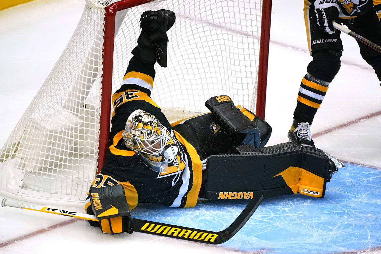 Pittsburgh Penguins goaltender Tristan Jarry sprawls across the goal crease during the first period...
