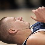 
              Denver Nuggets center Nikola Jokic reacts after getting hit in the face while jostling for a rebound with Dallas Mavericks center Dwight Powell in the first half of an NBA basketball game Friday, Oct. 29, 2021, in Denver. (AP Photo/David Zalubowski)
            