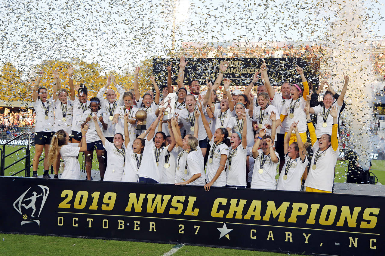 FILE - The North Carolina Courage celebrate with the championship trophy following their win over t...