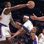 
              Memphis Grizzlies guard Ja Morant (12) drives to basket while defended by Los Angeles Lakers forward Kent Bazemore (9) and center DeAndre Jordan (10) during the first half of an NBA basketball game in Los Angeles, Sunday, Oct. 24, 2021. (AP Photo/Ringo H.W. Chiu)
            