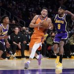 
              Phoenix Suns guard Devin Booker (1) moves with the ball between Los Angeles Lakers guard Malik Monk, left, and forward Kent Bazemore (9) during the first half of an NBA basketball game Friday, Oct. 22, 2021, in Los Angeles. (AP Photo/Marcio Jose Sanchez)
            
