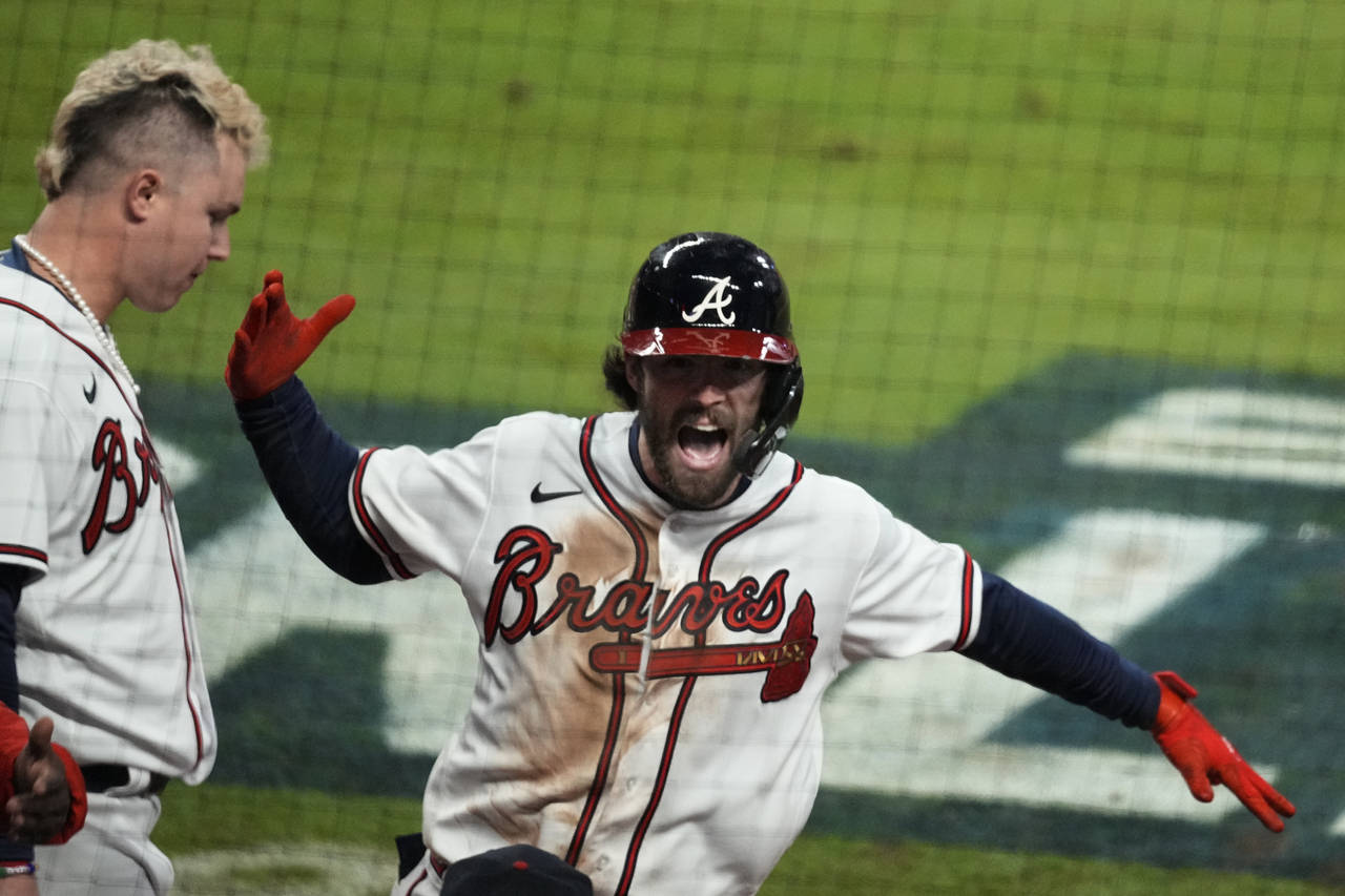 Atlanta Braves' Dansby Swanson celebrates a home run during the seventh inning in Game 4 of basebal...