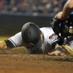 
              Arizona Diamondbacks' Daulton Varsho (12) gets a face full of dirt while sliding safe into home against the Colorado Rockies during the third inning of a baseball game Friday, Oct 1, 2021, in Phoenix. (AP Photo/Darryl Webb)
            