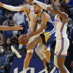
              Golden State Warriors guard Stephen Curry, center, passes the ball between Oklahoma City Thunder center Mike Muscala, rear, and guard Shai Gilgeous-Alexander during the first half of an NBA basketball game in San Francisco, Saturday, Oct. 30, 2021. (AP Photo/Jeff Chiu)
            