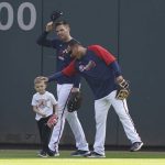 
              Atlanta Braves batting practice pitcher Tomas Perez reaches out to Charlie, son of Braves' Freddie Freeman, center, during a workout ahead of the NLCS playoff baseball game, Thursday, Oct. 14, 2021, in Atlanta. (AP Photo/Brynn Anderson)
            