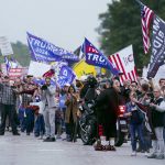 
              FILE - People protest as the motorcade for President Joe Biden passes by Oct. 5, 2021, in Howell, Mich. (AP Photo/Evan Vucci, File)
            