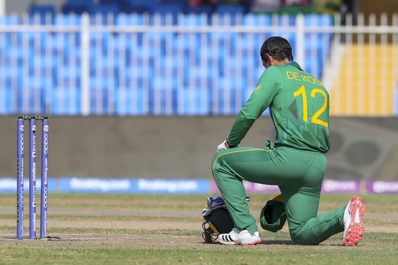 South Africa's Quinton de Kock kneels in support of the Black Lives Matter movement ahead of the Cr...