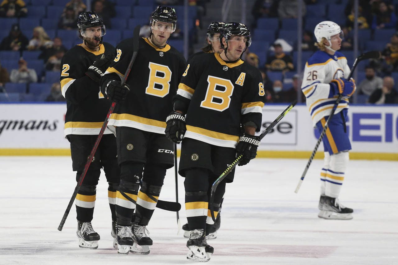 Boston Bruins center Charlie Coyle, center, skates alongside right wing Craig Smith, left, and cent...