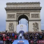 
              Kenyan marathon legend Eliud Kipchoge, center, poses for a group photo with the runners of the 5 kms (3,125 mils) "Marathon for all Paris 24" at the Champs Elysees avenue next to the Triumph Arc in Paris, Sunday, Oct. 31, 2021. Over 3'600 amateur runners faced off Sunday against Kenyan marathon legend Eliud Kipchoge in a special race in the heart of Paris, as the city prepares to host the 2024 Olympics. All those he fails to catch over the 5-kilomter race will win access to an Olympic-related marathon in 2024. (AP Photo/Michel Euler)
            