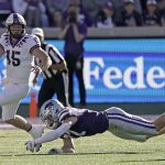 
              TCU quarterback Max Duggan (15) looks for a receiver under pressure from Kansas State defensive end Nate Matlack (97) during the first half of an NCAA college football game, Saturday, Oct. 30, 2021, in Manhattan, Kan. (AP Photo/Charlie Riedel)
            