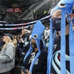 
              Seattle Kraken fans watch as the team takes the ice to warm up Saturday, Oct. 23, 2021, in Seattle, for the NHL hockey expansion team's home-opener against the Vancouver Canucks. (AP Photo/Elaine Thompson)
            