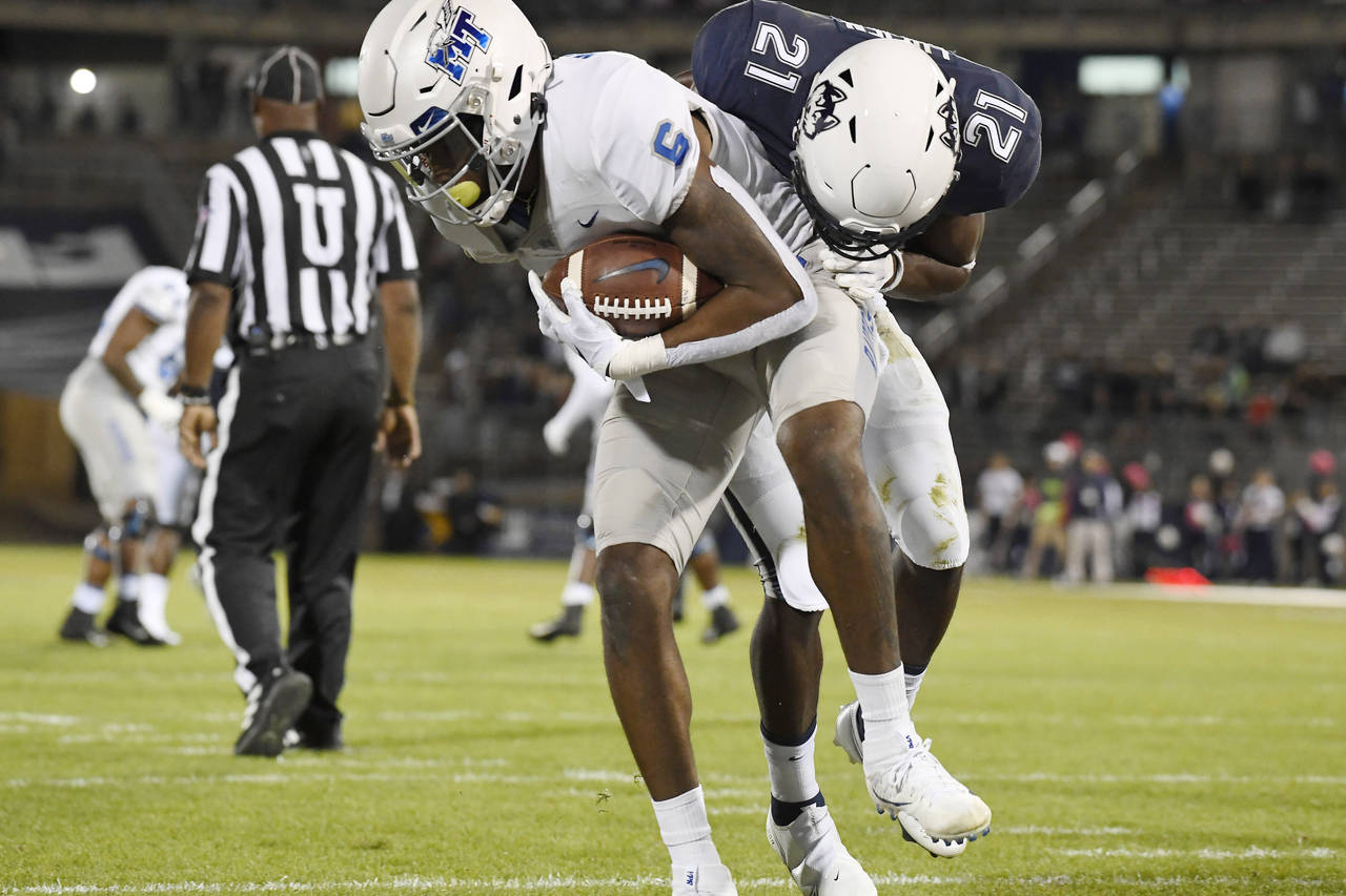 Middle Tennessee State's Jimmy Marshall, front left, scores a touchdown while Connecticut's Jeremy ...