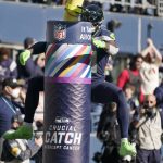 
              Seattle Seahawks' DK Metcalf leaps to wrap himself around a goalpost after scoring a touchdown against the Jacksonville Jaguars during the first half of an NFL football game, Sunday, Oct. 31, 2021, in Seattle. (AP Photo/Ted S. Warren)
            