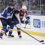 
              Colorado Avalanche's J.T. Compher (37) and St. Louis Blues' Jake Walman (46) chase after a loose puck during the first period of an NHL hockey game Thursday, Oct. 28, 2021, in St. Louis. (AP Photo/Jeff Roberson)
            