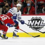 
              Toronto Maple Leafs' John Tavares (91) moves the puck away from a challenge by Carolina Hurricanes' Jordan Martinook (48) during the first period of an NHL hockey game in Raleigh, N.C., Monday, Oct. 25, 2021. (AP Photo/Karl B DeBlaker)
            
