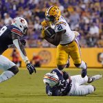 
              LSU running back Corey Kiner (21) carries against Auburn safety Zion Puckett (10) and safety Bydarrius Knighten (19) during the first half of an NCAA college football game in Baton Rouge, La., Saturday, Oct. 2, 2021. (AP Photo/Gerald Herbert)
            