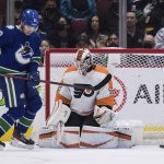 
              Philadelphia Flyers goalie Martin Jones, right, makes a save as Vancouver Canucks' Vasily Podkolzin, of Russia, stands in front of him during the first period of an NHL hockey game Thursday, Oct. 28, 2021, in Vancouver, British Columbia. (Darryl Dyck/The Canadian Press via AP)
            
