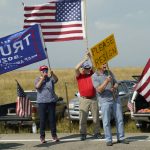 
              FILE - Protesters hold signs on the side of the road as seen through the window of a motorcade vehicle traveling with President Joe Biden to the Flatirons Campus of the National Renewable Energy Laboratory, on Sept. 14, 2021, in Arvanda, Colo. (AP Photo/Evan Vucci)
            