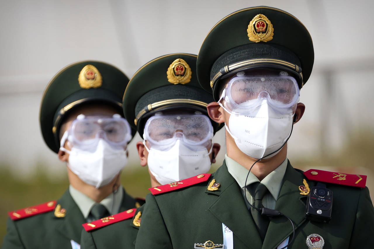 Chinese paramilitary police wearing goggles and face masks march in formation at the Yanqing Nation...