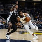 
              Indiana Pacers forward Oshae Brissett (12) drives on San Antonio Spurs guard Lonnie Walker IV (1) during the second half of an NBA basketball game in Indianapolis, Monday, Nov. 1, 2021. The Pacers defeated the Spurs 131-118. (AP Photo/Michael Conroy)
            