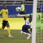 
              United States' Tim Weah (20) scores his side's opening goal against Jamaica during a qualifying soccer match for the FIFA World Cup Qatar 2022 in Kingston, Jamaica, Tuesday, Nov. 16, 2021. (AP Photo/Fernando Llano)
            