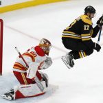 
              Boston Bruins' Nick Foligno (17) jumps as the puck goes wide of Calgary Flames' Dan Vladar (80) during the second period of an NHL hockey game, Sunday, Nov. 21, 2021, in Boston. (AP Photo/Michael Dwyer)
            