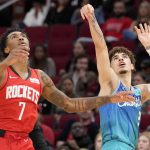 
              Charlotte Hornets guard LaMelo Ball, right, watches his three point basket as Houston Rockets guard Armoni Brooks (7) defends during the first half of an NBA basketball game, Saturday, Nov. 27, 2021, in Houston. (AP Photo/Eric Christian Smith)
            