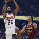 
              Phoenix Suns' Mikal Bridges (25) drives to the basket against Cleveland Cavaliers' Isaac Okoro (35) during the first half of an NBA basketball game Wednesday, Nov. 24, 2021, in Cleveland. (AP Photo/Tony Dejak)
            