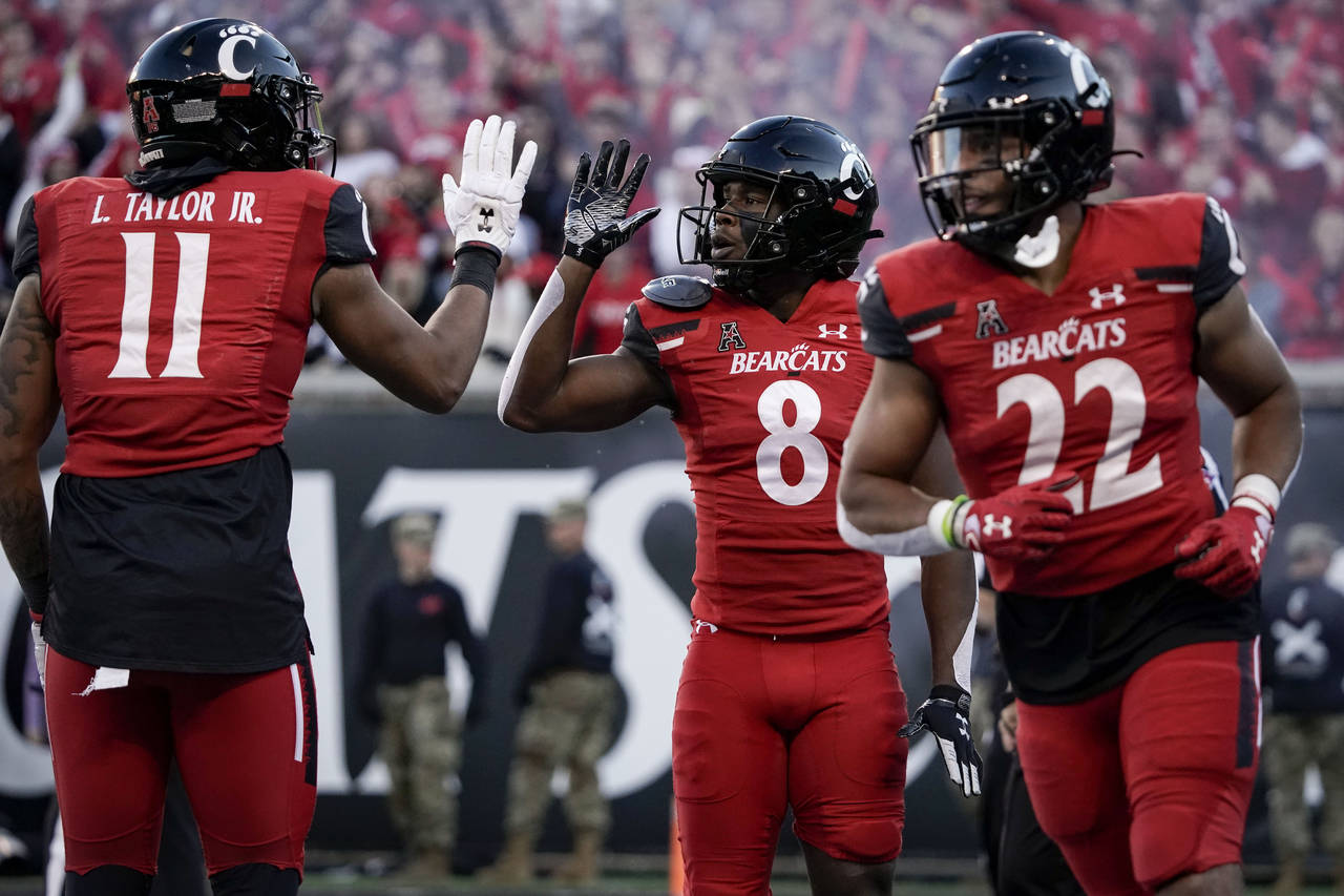 Cincinnati wide receiver Michael Young Jr. (8) celebrates with tight end Leonard Taylor (11) after ...