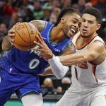 
              Phoenix Suns guard Devin Booker (1) fouls Minnesota Timberwolves guard D'Angelo Russell (0) who goes to the basket in the fourth quarter of an NBA basketball game Monday, Nov. 15, 2021, in Minneapolis. (AP Photo/Bruce Kluckhohn)
            