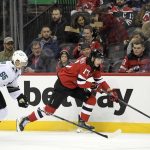 
              New Jersey Devils center Yegor Sharangovich (17) skates with the puck as he is pursued by San Jose Sharks defenseman Erik Karlsson (65) during the first period of an NHL hockey game Tuesday, Nov. 30, 2021, in Newark, N.J. (AP Photo/Bill Kostroun)
            