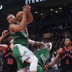 
              Boston Celtics' Grant Williams, top, grabs a defensive rebound as Toronto Raptors' Scottie Barnes looks on during the second half of an NBA basketball game Sunday, Nov. 28, 2021 in Toronto. (Chris Young/The Canadian Press via AP)
            