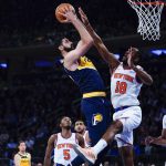 
              Indiana Pacers' Goga Bitadze, center, shoots over New York Knicks' Alec Burks (18) during the first half of an NBA basketball game Monday, Nov. 15, 2021, in New York. (AP Photo/Frank Franklin II)
            