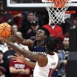 
              Navy forward Tyler Nelson (5) blocks the shot of Louisville guard Dre Davis (14) during the first half of an NCAA college basketball game in Louisville, Ky., Monday, Nov. 15, 2021. (AP Photo/Timothy D. Easley)
            