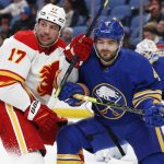 
              Calgary Flames left wing Milan Lucic (17) and Buffalo Sabres defenseman Will Butcher (4) battle for position during the second period of an NHL hockey game, Thursday, Nov. 18, 2021, in Buffalo, N.Y. (AP Photo/Jeffrey T. Barnes)
            