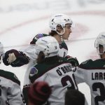 
              Arizona Coyotes right wing Clayton Keller, top, is congratulated by teammates on the bench after his goal against the Minnesota Wild during the first period of an NHL hockey game Tuesday, Nov. 30, 2021, in St. Paul, Minn. (AP Photo/Stacy Bengs)
            