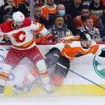 
              Calgary Flames' Elias Lindholm, left, and Philadelphia Flyers' Sean Couturier collide during the second period of an NHL hockey game, Tuesday, Nov. 16, 2021, in Philadelphia. (AP Photo/Matt Slocum)
            